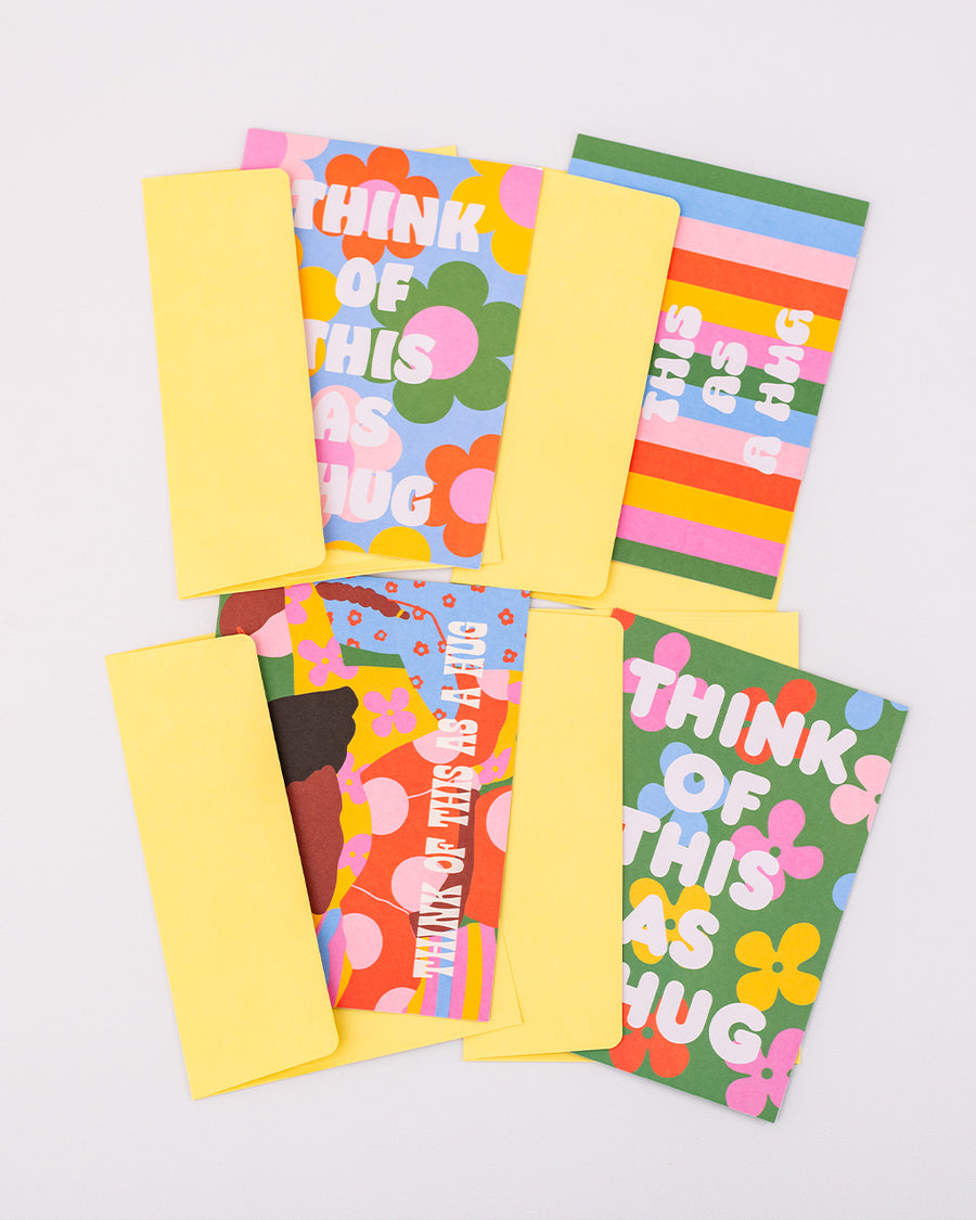 up close of set of 20 greeting cards with 4 styles of 'think of this as a hug' and matching envelopes