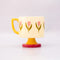 side view of top view of cream 10 oz ceramic mug with yellow handle, pink pedestal base and pink tulip print