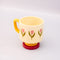 top view of cream 10 oz ceramic mug with yellow handle, pink pedestal base and pink tulip print