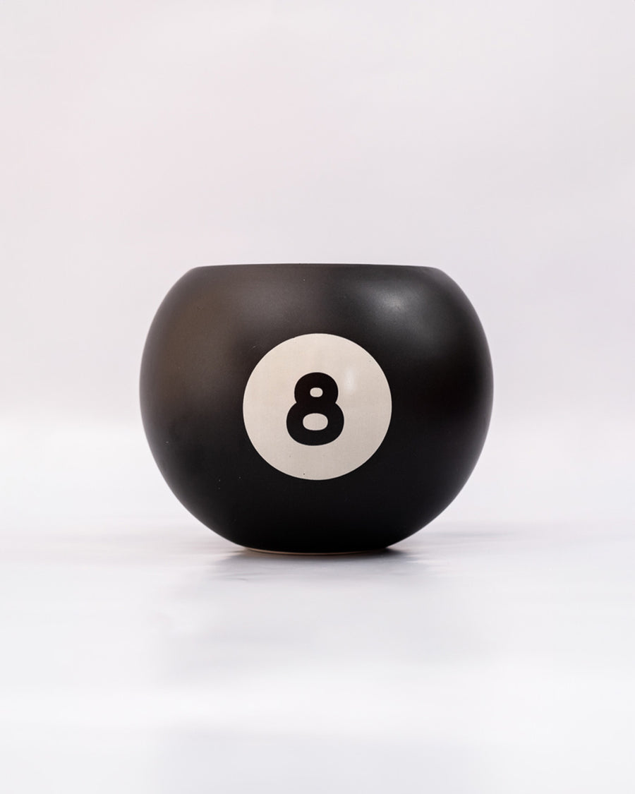 black magic 8 ball shaped vase on a grey ground