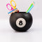 black magic 8 ball shaped vase with pencils and desk accessories inside