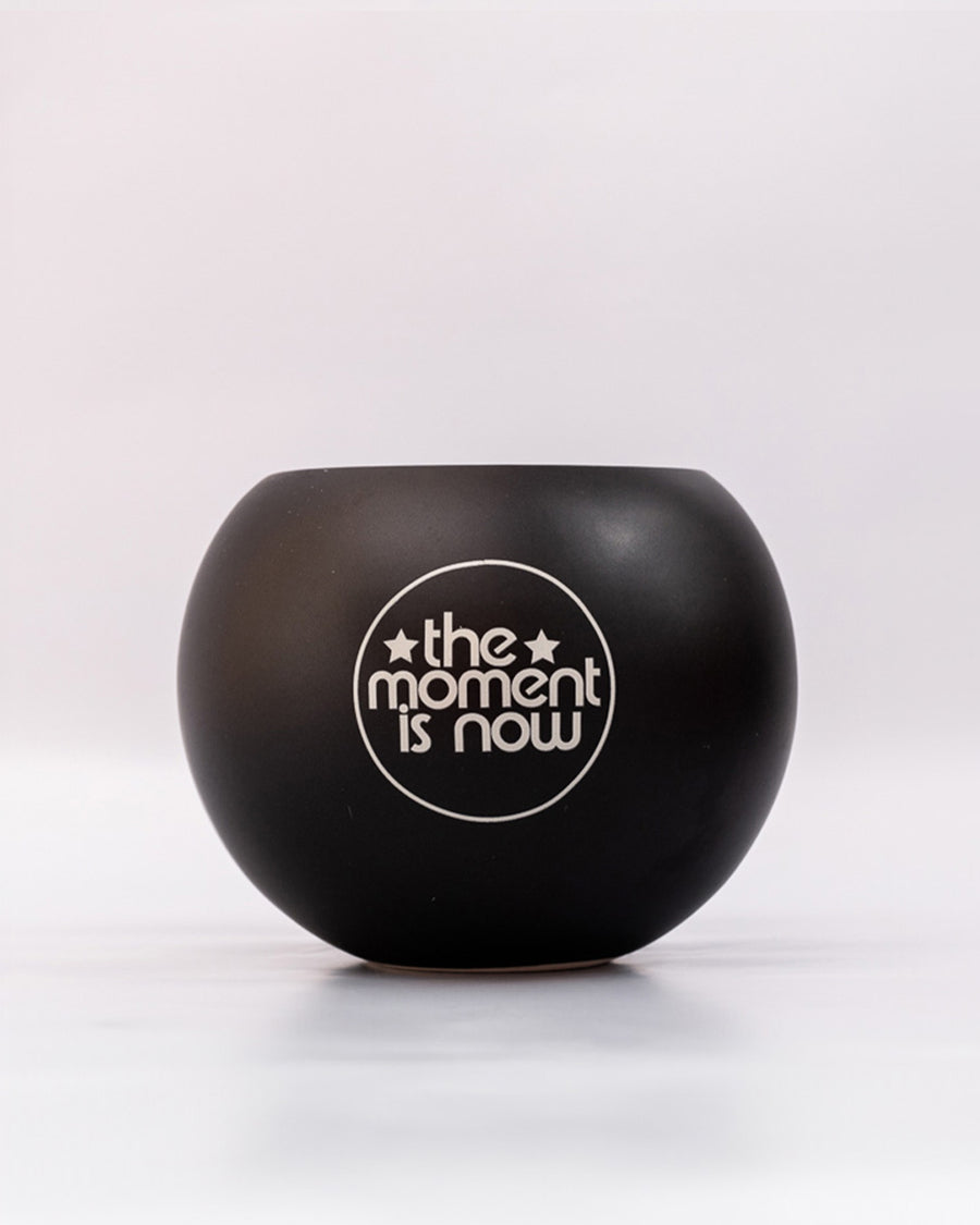 'the moment is now' back message on black magic 8 ball shaped vase