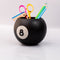 side view of black magic 8 ball shaped vase with pencils and desk accessories inside