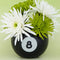 black magic 8 ball shaped vase with flowers inside