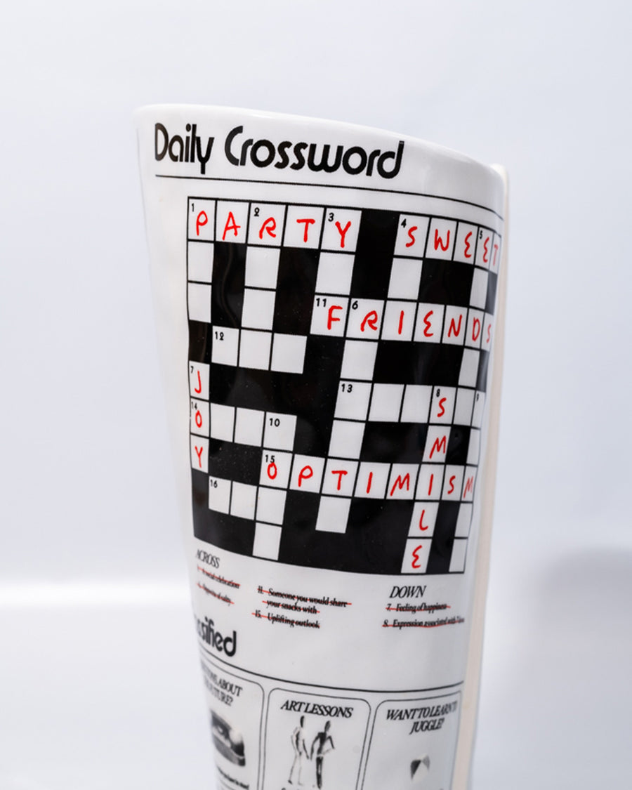 up close of crossword puzzle on rolled newspaper shaped vase