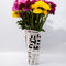 rolled newspaper shaped vase with flowers inside