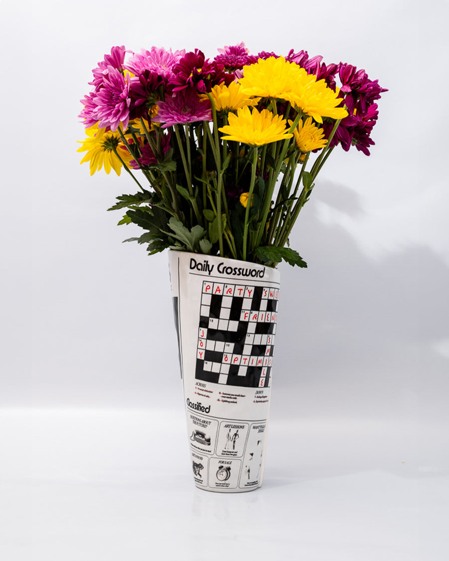 rolled newspaper shaped vase with flowers inside