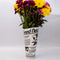 rolled newspaper shaped vase with flowers inside