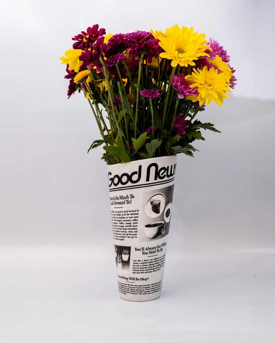 rolled newspaper shaped vase with flowers inside