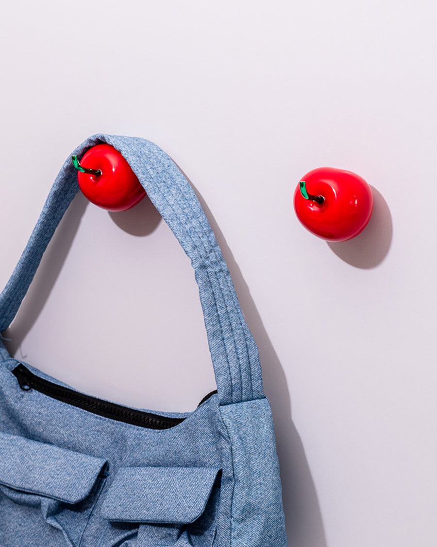 side view of blue baggu bag on cherry shaped hooks