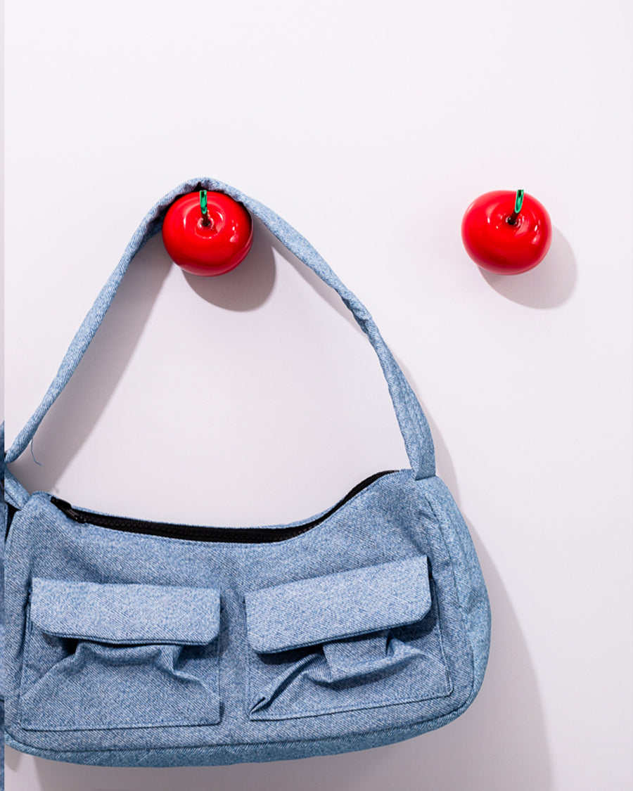 front view of blue baggu bag on cherry shaped hooks