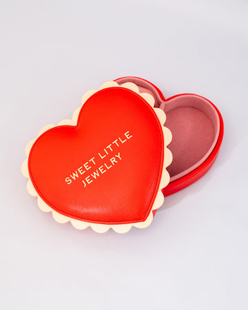 red heart shaped jewelry box with pink interior and cream scalloped detail with 'sweet little jewelry' across the front