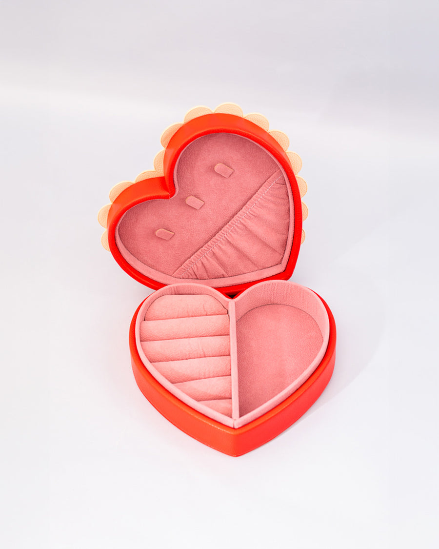 interior of red heart shaped jewelry box with pink interior and cream scalloped detail with 'sweet little jewelry' across the front