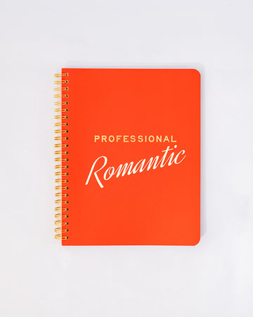 red mini notebook with gold and white 'professional romantic' across the front