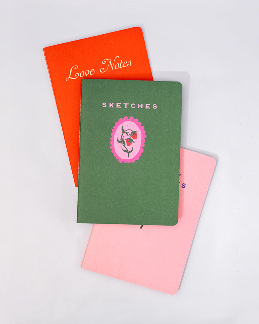 set of three purse size notebooks: pink sleepy thoughts, green sketches and red love notes stacked on each other