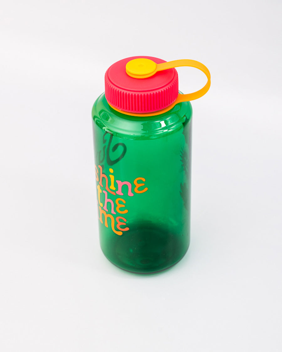 side view of green nalgene like bottle with pink lid, yellow strap and colorful 'sunshine all the time' across the front