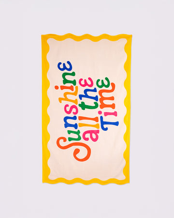 cream oversized towel with colorful 'sunshine all the time' typography and yellow scalloped trim