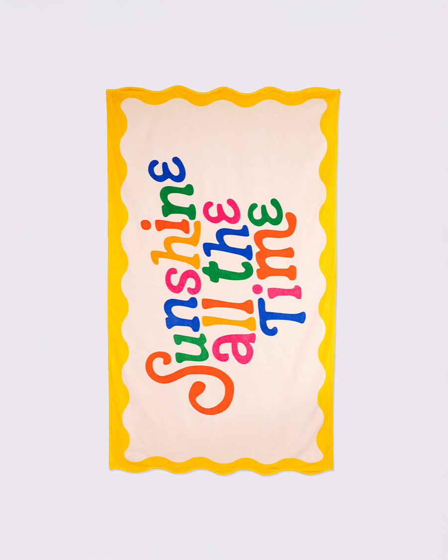 cream oversized towel with colorful 'sunshine all the time' typography and yellow scalloped trim