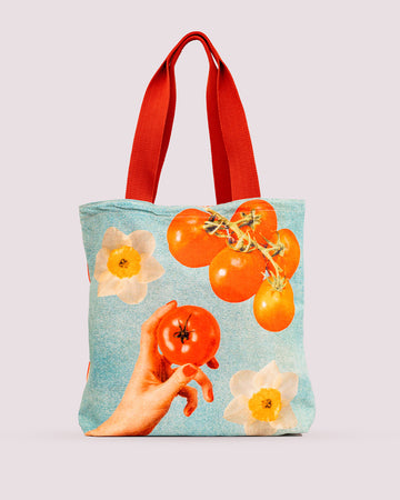 tote bag that says realistic model holding tomato with tomato vine and daffodil print 