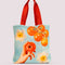 tote bag that says realistic model holding tomato with tomato vine and daffodil print 