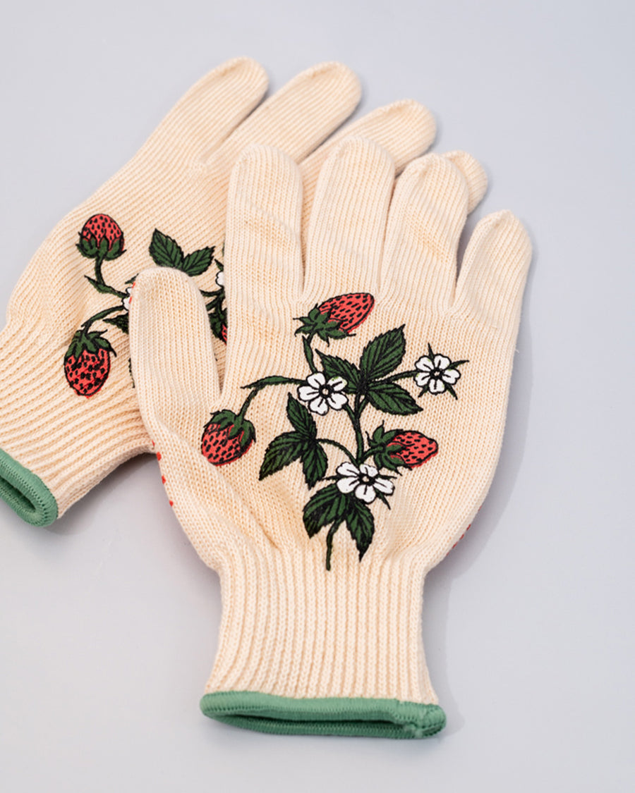 up close of cream gardening gloves with white flower and strawberry print and green trim