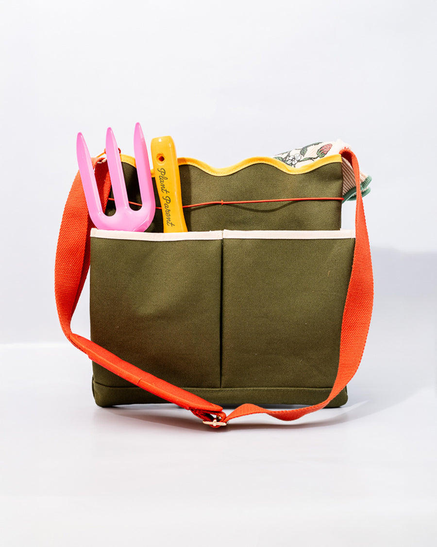 army green canvas gardening tool bag with red strap and yellow scalloped top edge with garden tools inside