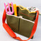 side view of army green canvas gardening tool bag with red strap and yellow scalloped top edge and tools inside