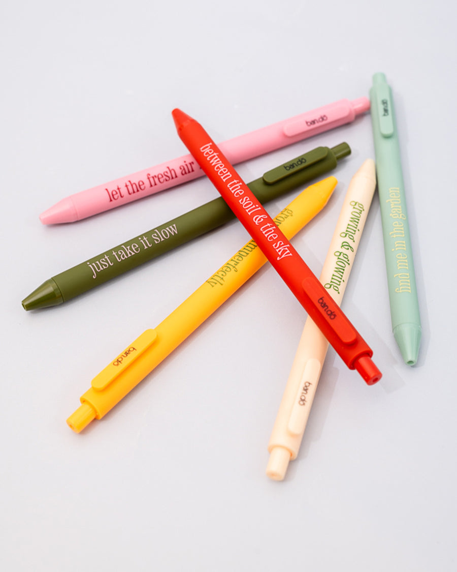 scattered set of 6 colorful clickable pen set with various gardening sayings