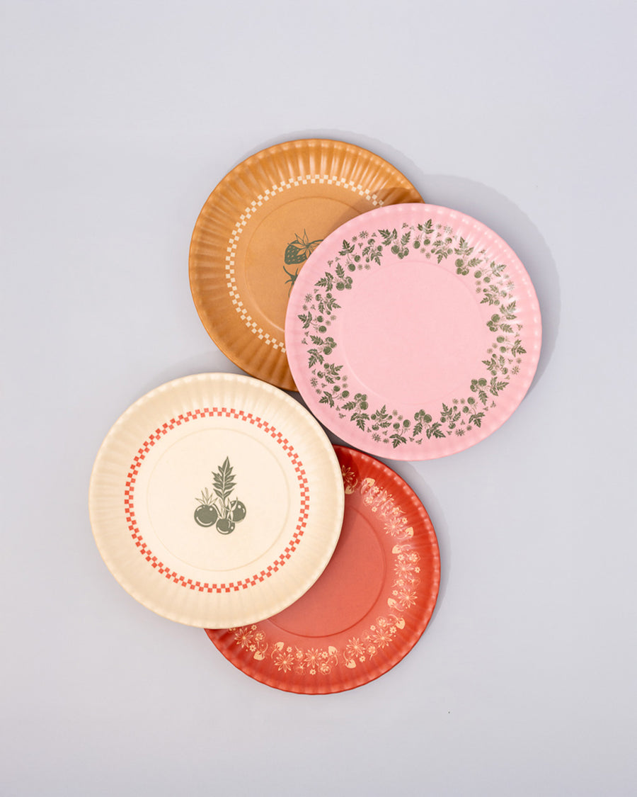 set of 4 dessert plates with ridge edges: golden strawberry, pink with green garden border, cream with green plant print and red checkered border and red with golden garden border stacked on each other