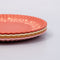 side view of set of 4 dessert plates with ridge edges: golden strawberry, pink with green garden border, cream with green plant print and red checkered border and red with golden garden border stacked on each other