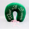 front view of green velvet travel pillow with white 'what a dream' with pink bow