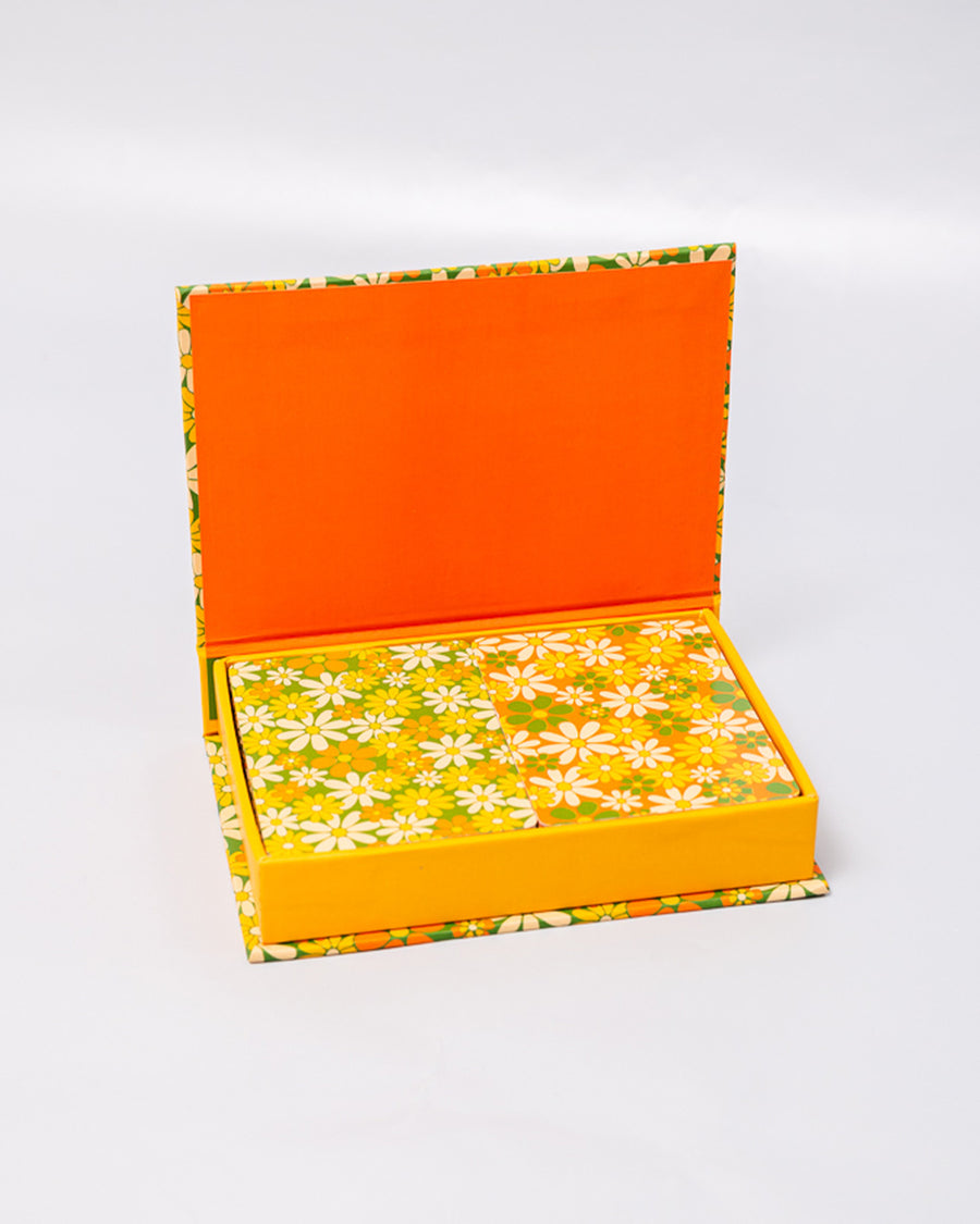 opened box of set of two retro floral playing card decks with yellow, gold and green flowers