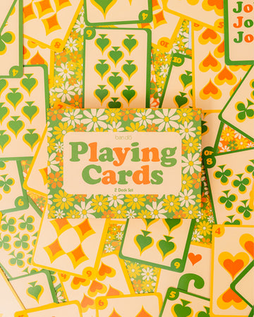 set of two retro floral playing card decks with yellow, gold and green flowers