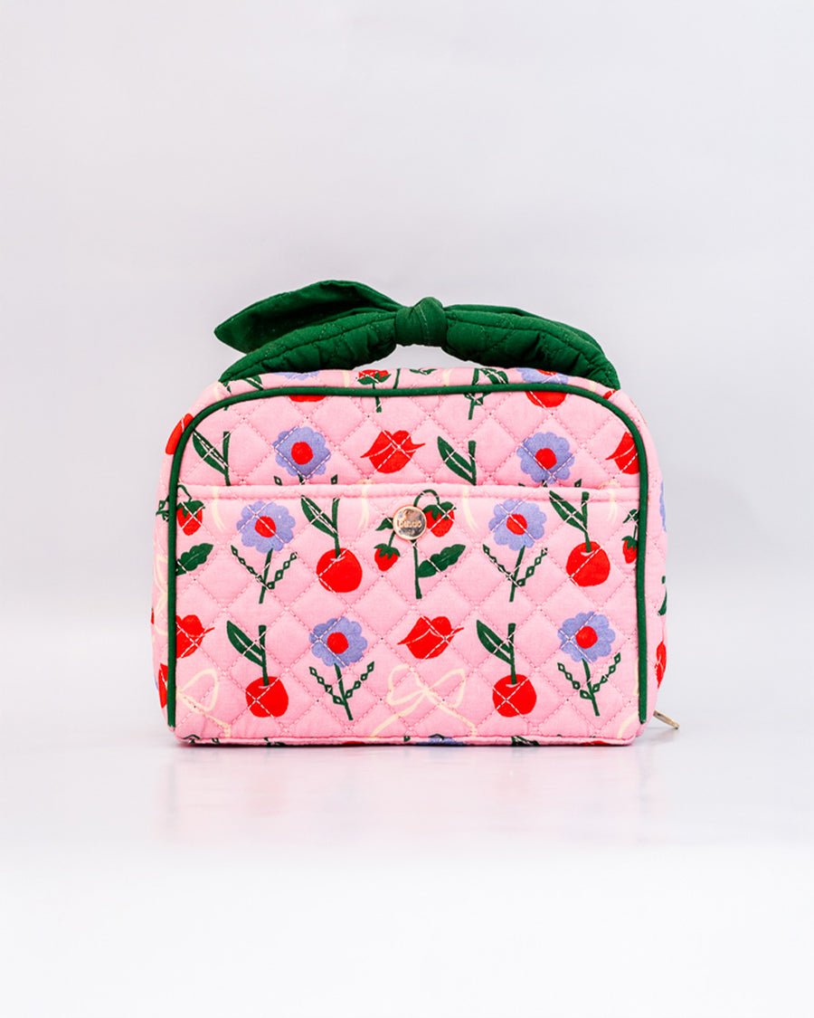 pink quilted toiletry bag with green bow handle and all over periwinkle flower, cherries, bow and lip print