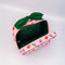 green interior of pink quilted toiletry bag with green bow handle and all over periwinkle flower, cherries, bow and lip print