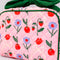 up close of pink quilted toiletry bag with green bow handle and all over periwinkle flower, cherries, bow and lip print