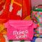 pink rubber waterproof bag with white 'make a splash' with yellow strap