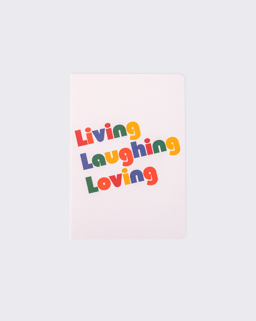 white notebook that says Living Laughing Loving in bold, colorful letters