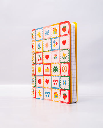 white mini notebook with colorful patchwork design (bows, heart, pretzel, strawberry etc)