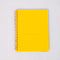 yellow interior pocket of white mini notebook with colorful patchwork design (bows, heart, pretzel, strawberry etc)