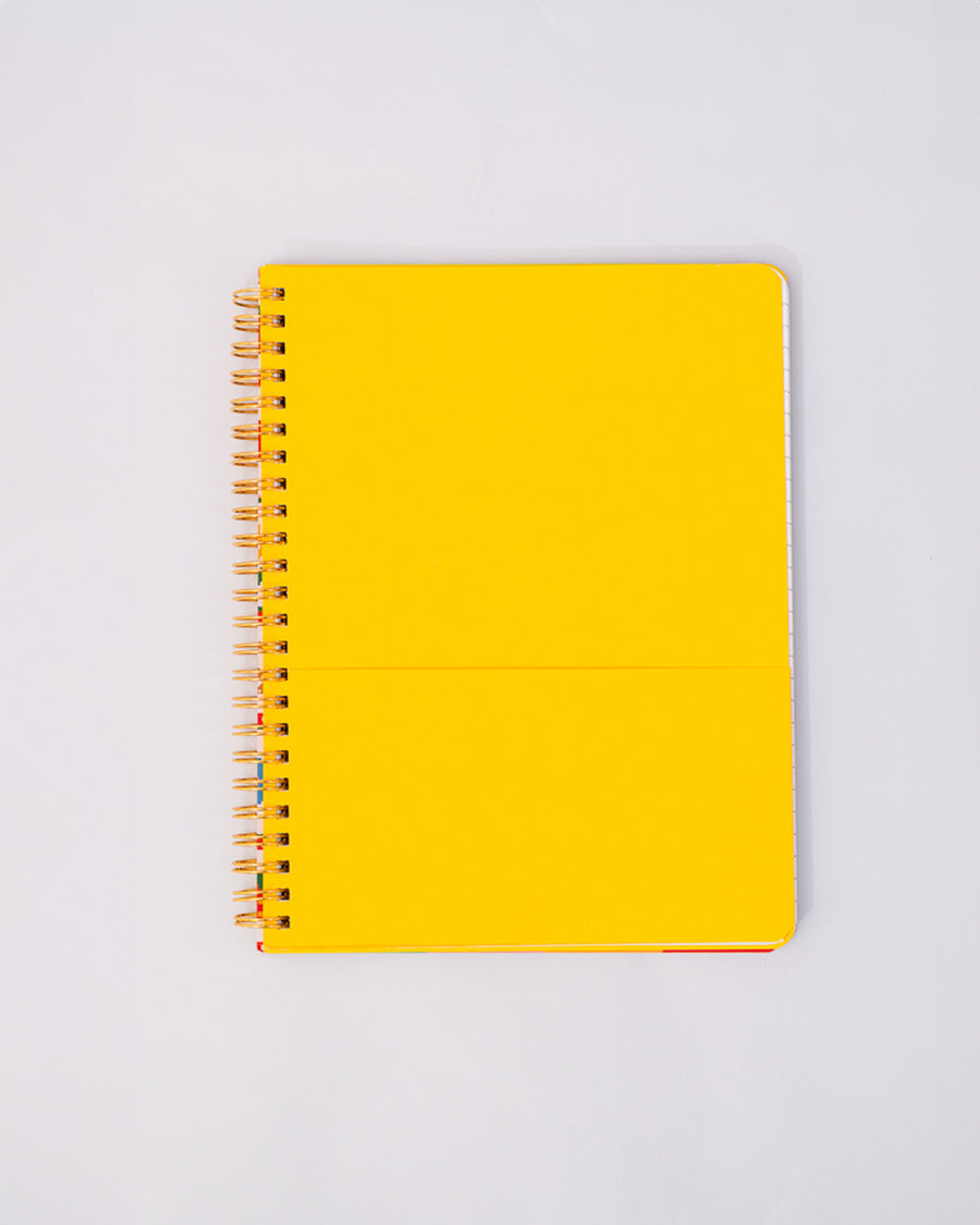 yellow interior pocket of white mini notebook with colorful patchwork design (bows, heart, pretzel, strawberry etc)