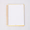 white lined paper inside of white mini notebook with colorful patchwork design (bows, heart, pretzel, strawberry etc)