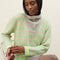 model wearing grey sweater with button funnel neckline and green abstract floral print