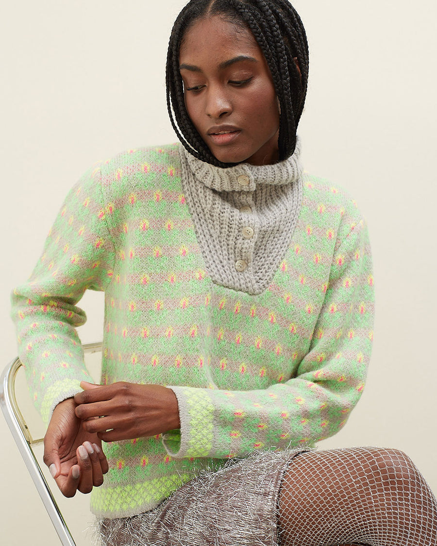 model wearing grey sweater with button funnel neckline and green abstract floral print