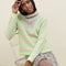 model wearing grey sweater with button funnel neckline and green abstract floral print