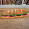 long hoagie shaped throw rug with lettuce, cheese and 'deli meat' center on a floor