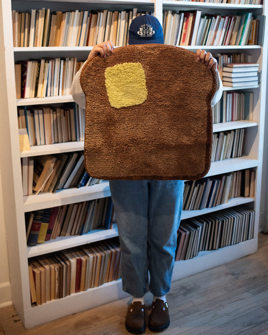 model holding toast and butter shaped throw rug