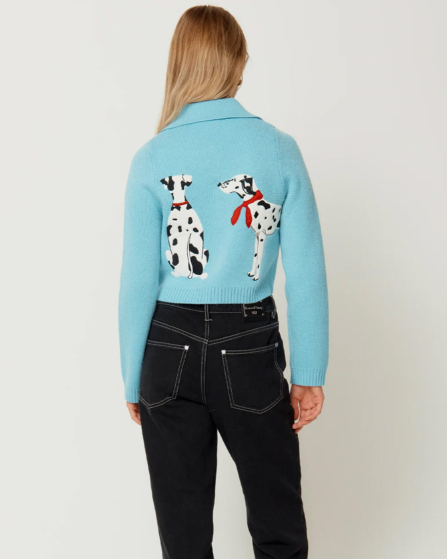 back view of model wearing light blue cropped cardigan with Dalmatian wearing a red beret design wrapping across the side and back