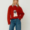 front view of model wearing red oversized crew sweater with pug wearing a blue bow and bandana on the front