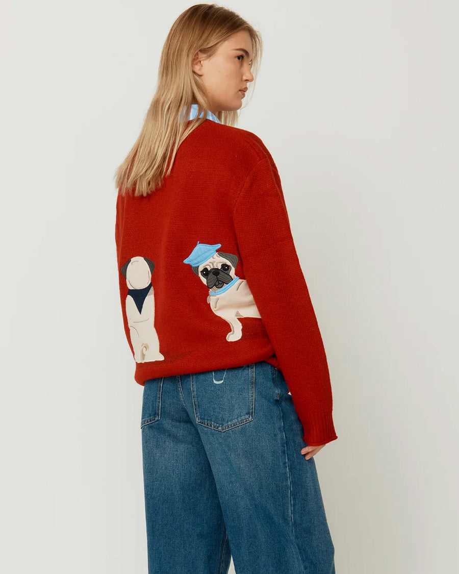 back view of model wearing red oversized crew sweater with pug wearing a blue beret on the back